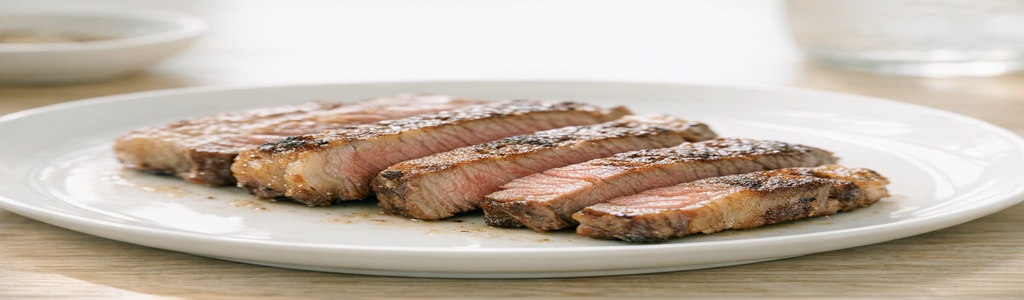 Minimalist carnivore meal with ribeye slices in warm natural light