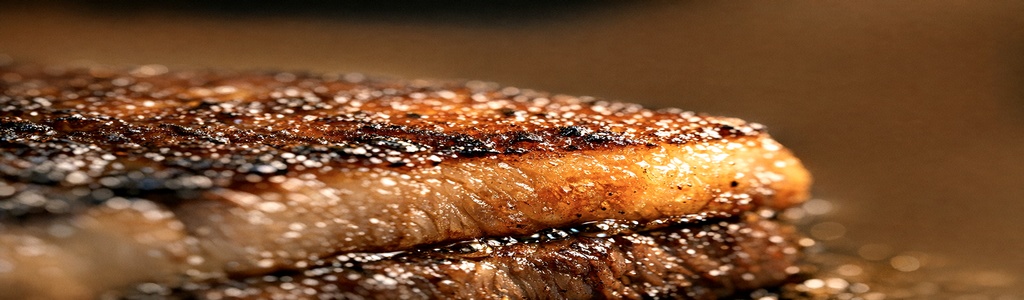 Seared ribeye steak on rustic cutting board with warm lighting 